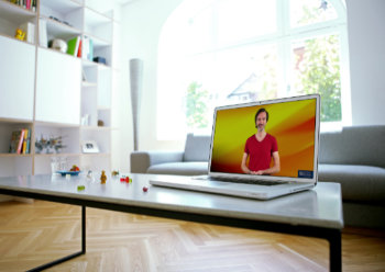 Gesangstraining online mit einem Laptop auf einem Tisch im Wohnzimmer